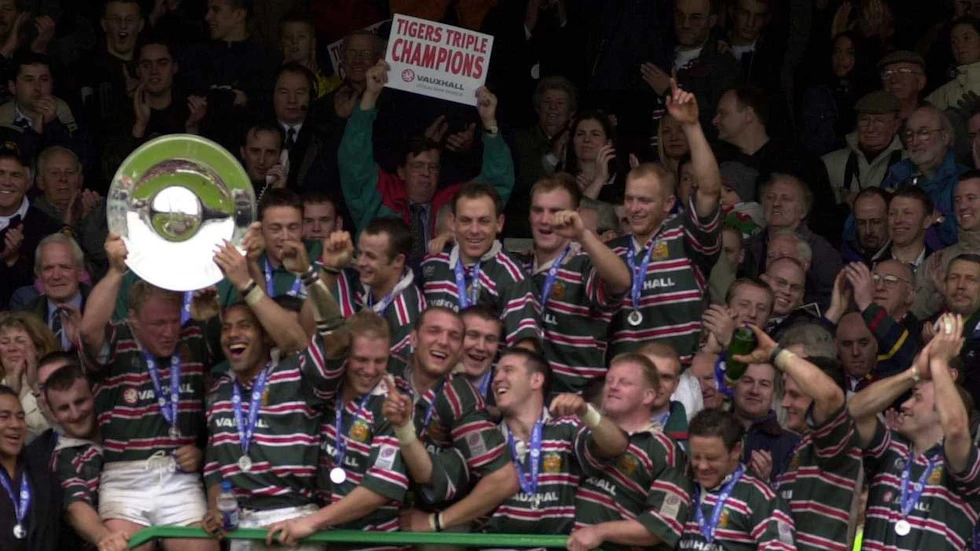The 2001/02 Leicester Tigers treble winning squad lifting a trophy.